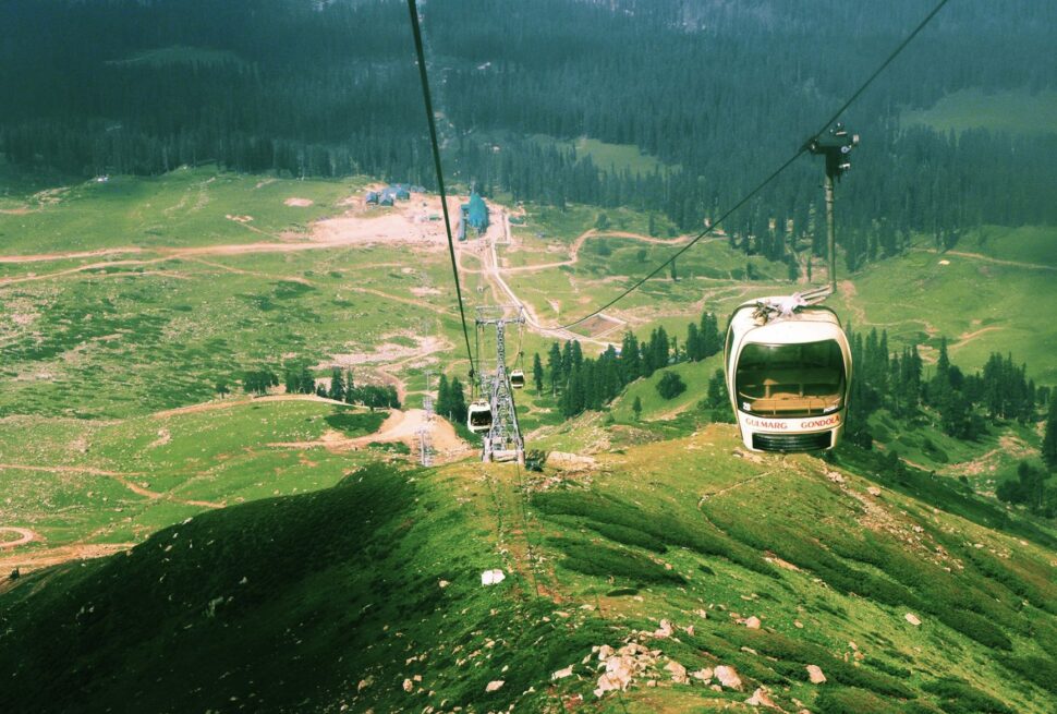 Experience a breathtaking aerial view riding the Gulmarg Gondola in Kashmir's stunning landscape.