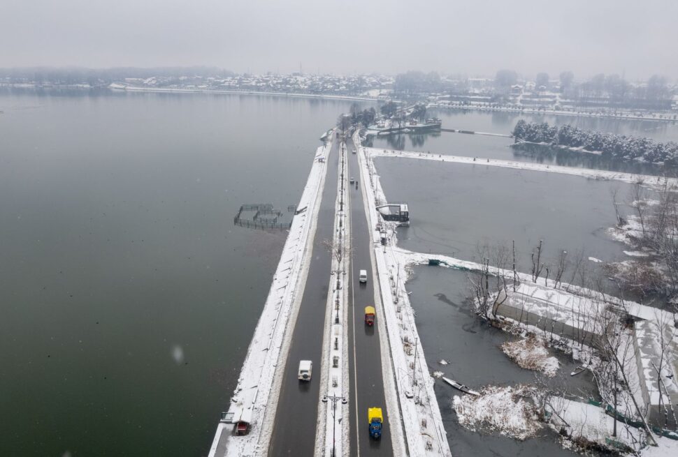 Aerial shot of a snow-covered bridge and road in Srinagar, Kashmir, during winter.