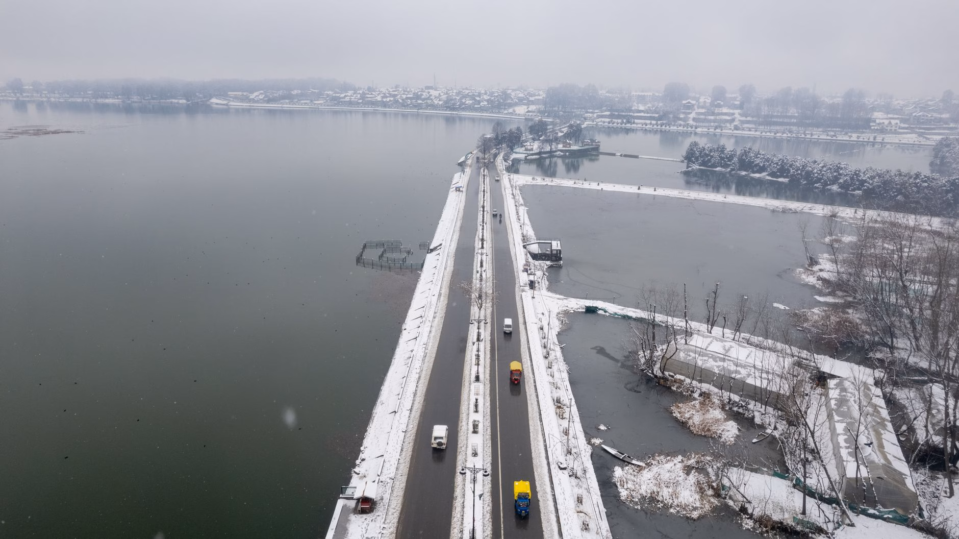 Aerial shot of a snow-covered bridge and road in Srinagar, Kashmir, during winter.
