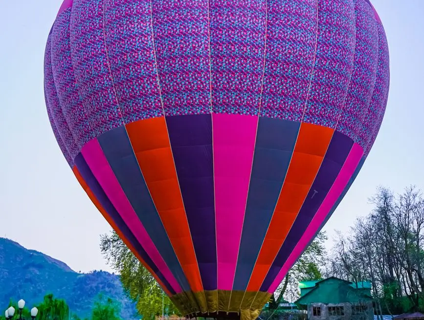 A vibrant hot air balloon at a festival in the picturesque landscapes of Kashmir.